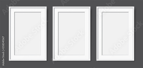 3 white wooden frames with passepartout, hanging on the dark wall background. Realistic blank frames mockup, for text or image placement. Empty elegant frames vector template with copy space.