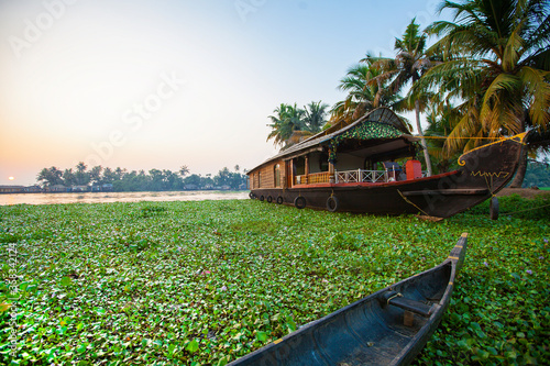 Beautiful sunset with houseboat in the backwaters of Kerala, India