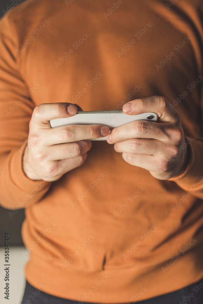 Fototapeta premium man using mobile phone with both hands