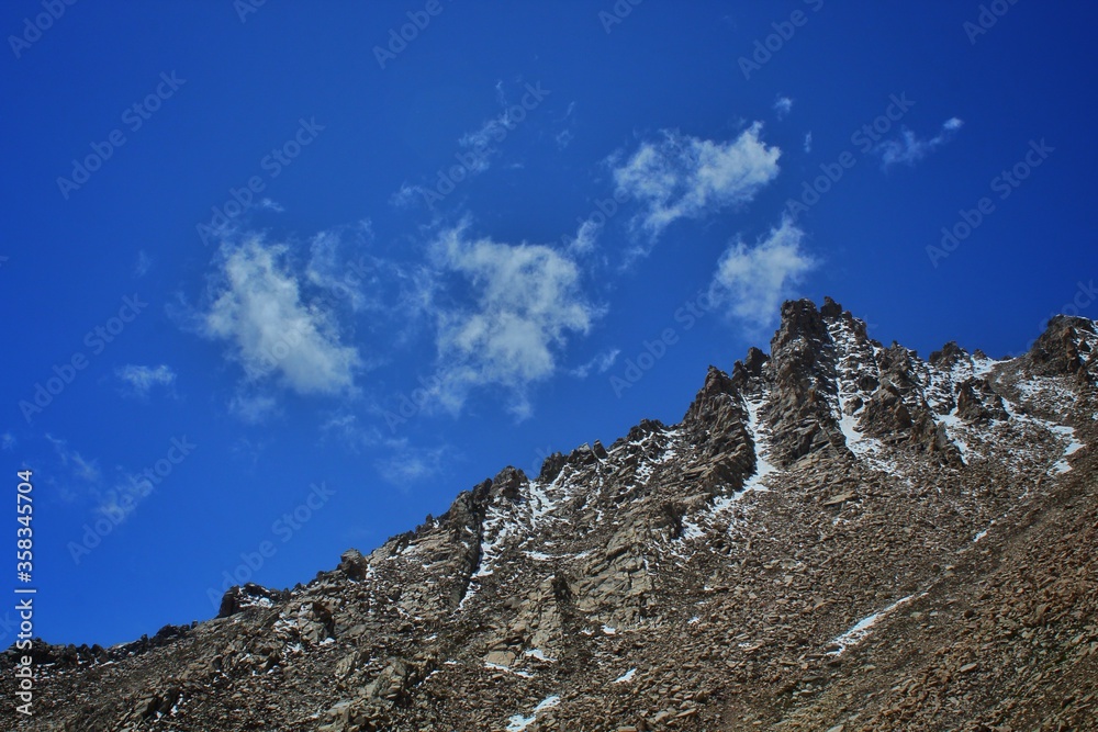 scenic view of a mountains with a blue sky and clouds above.