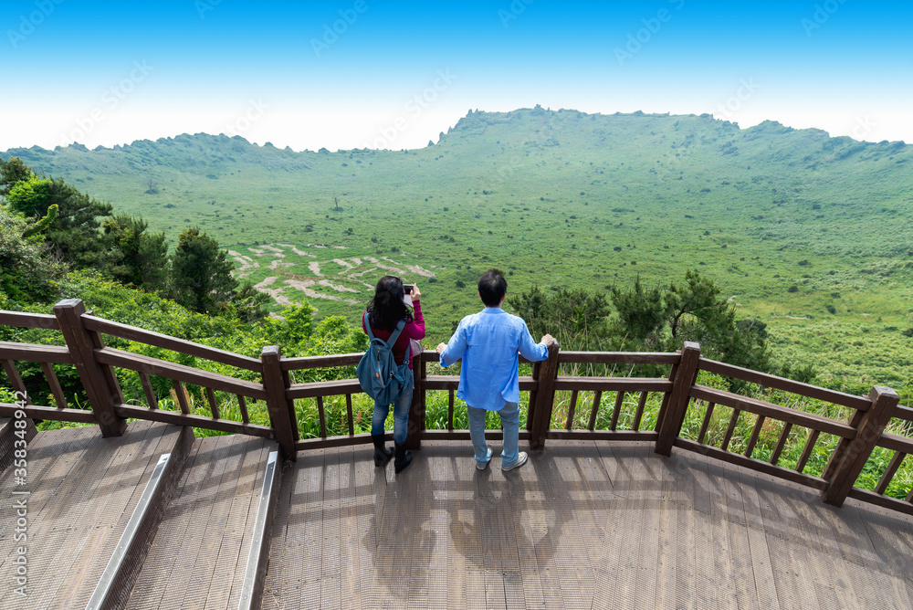 Man and Women looking Crater View of Songsan Ilchulbong in jeju island. Man and Women looking Crater View of Songsan Ilchulbong in jeju island.