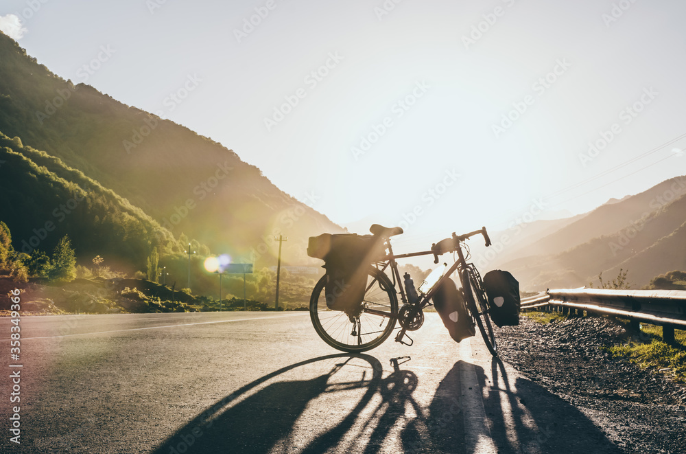 Background image of standing touring bicycle without cyclist on the road with nocars. Cycling in a countryside. Kazkbegi nationalpark. Georgia.2020