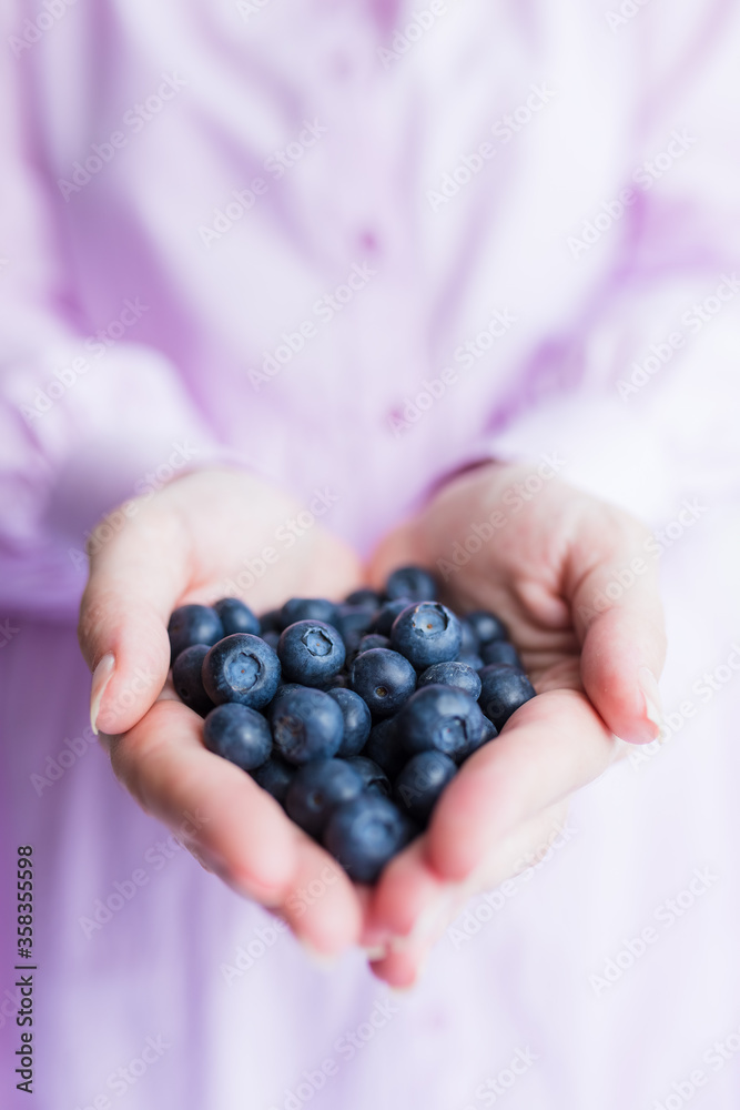 Close up of female hands holding tasty ripe blueberries Close up of female hands holding tasty ripe blueberries