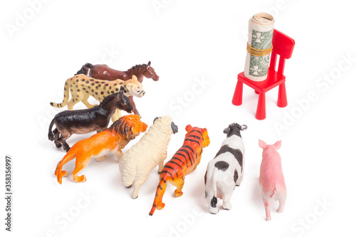 Fototapeta Naklejka Na Ścianę i Meble -  Toy plastic figurines of animals on white isolated background. Crowd of animals in front of a bundle of money. The concept of the desire to make money. People love money more than anything.