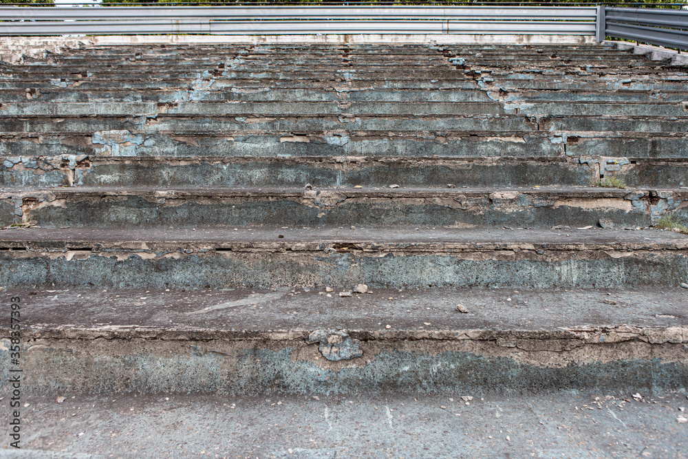 close up photo of the old, cracked steps to the abandoned stadium
