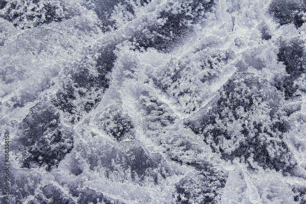 Transparent ice background. Close up of ice formation used as abstract background. Network of cracks in thick solid layer of ice of a frozen river. Transparent ice background. Close up of ice formation used as abstract background. Network of cracks in thick solid layer of ice of a frozen river.