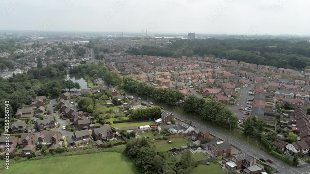 Aerial slow lowering view above British Northwest neighbourhood housing estate rooftops Aerial slow lowering view above British Northwest neighbourhood housing estate rooftops