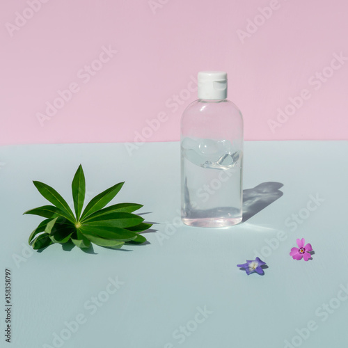 Bottle of antiseptic on blue pink background.