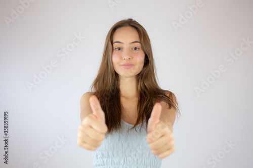 Pretty young girl making fingers up gesture