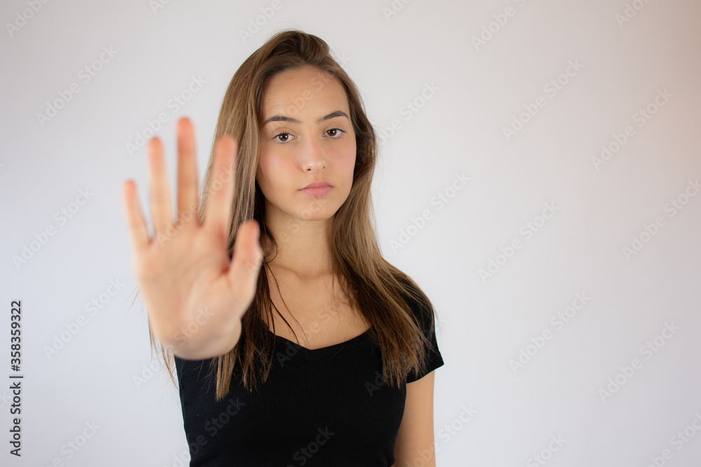 Pretty young girl making stop hand gesture Pretty young girl making stop hand gesture