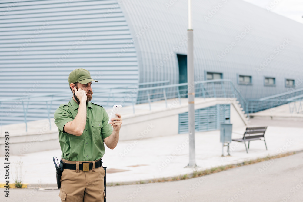 Obraz premium security guard in uniform and armed working on the safety of buildings