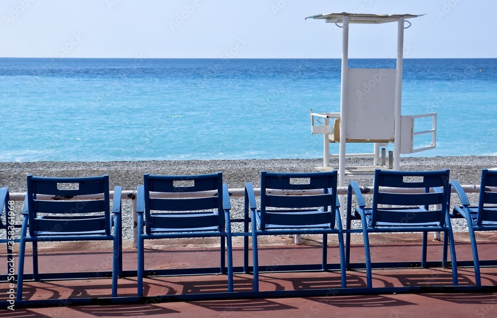 Tipiche sedie in fronte al mare della Costa Azzurra e torre assistenza bagnanti