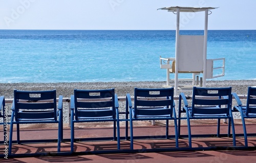 Tipiche sedie in fronte al mare della Costa Azzurra e torre assistenza bagnanti