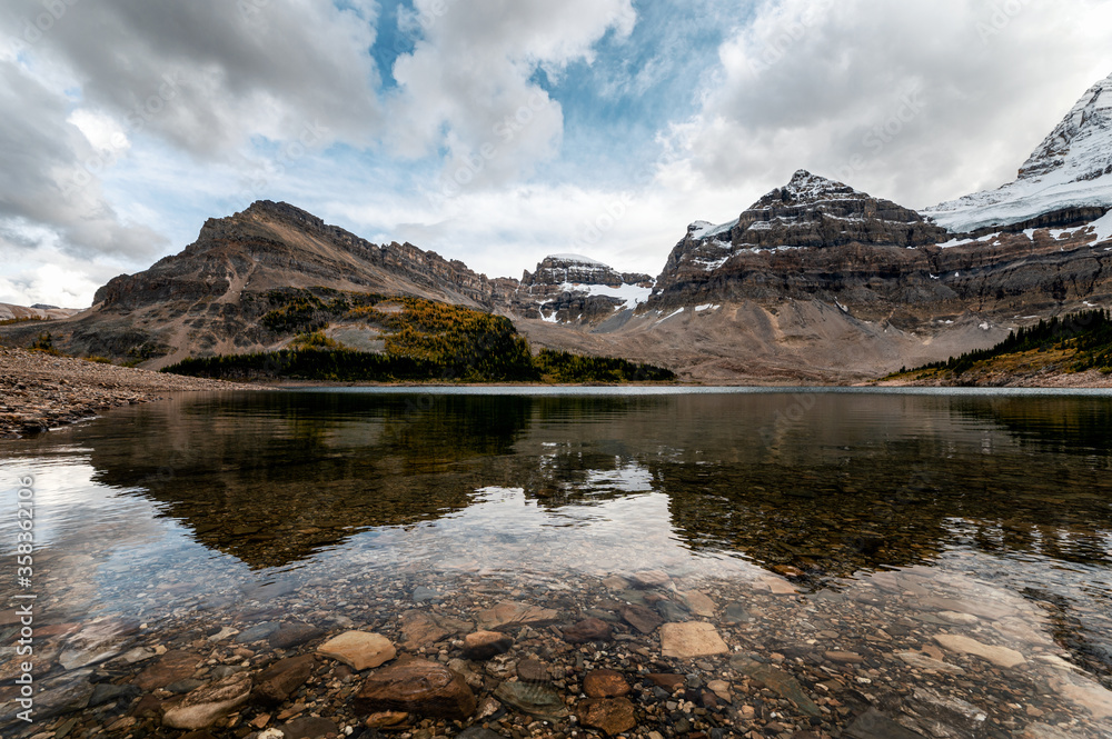 Rocky mountains with cloudy in blue sky reflection on Lake Magog, Assiniboine provincial park Rocky mountains with cloudy in blue sky reflection on Lake Magog, Assiniboine provincial park