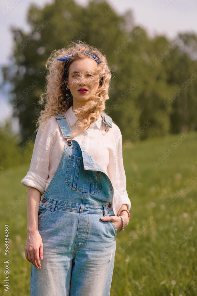 girl in denim overalls enjoys the wind in nature girl in denim overalls enjoys the wind in nature