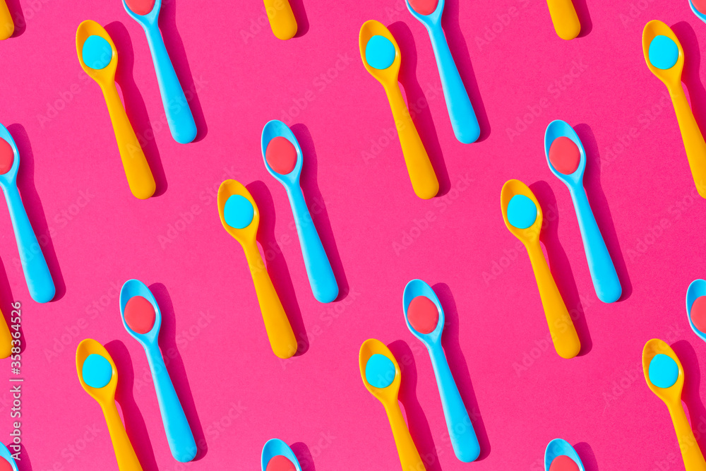 Seamless pattern of yellow and blue plastic teaspoons with blue and red liquid Seamless pattern of yellow and blue plastic teaspoons with blue and red liquid
