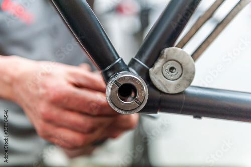 Bicycle mechanic working at inner bearing of bike photo