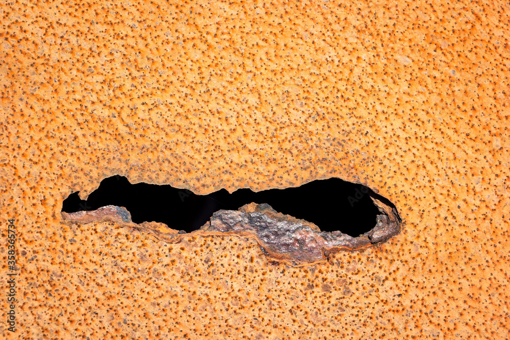An iron plate as background. There is a crack in the rusty metal.