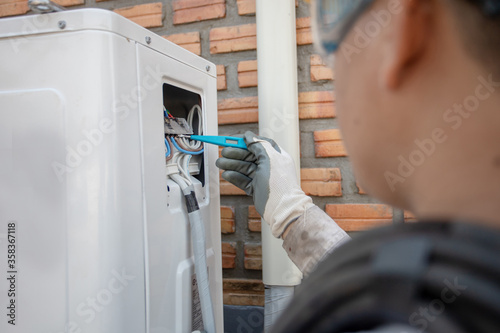 Air Conditioning Technician and A part of preparing to install new air conditioner. Technician vacuum pump evacuates and checking new air conditioner