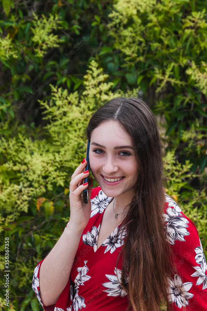 Happy young woman making a call