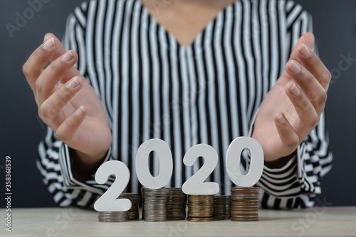 Business woman holding hands apart above money 2020 financial economy concept