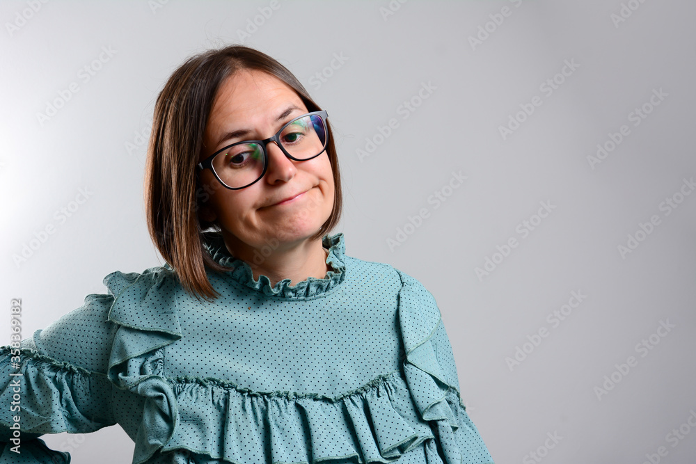 Young business woman made a mistake, studio photo isolated on a gray background. disappointed young woman with glasses. Serious woman