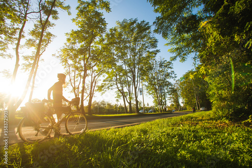 Image of man pushing touring bicycle during scenic sunset, Croatia.