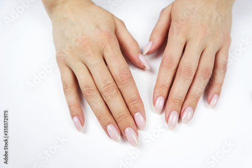 Classic pink manicure. Young woman s hands on white background.