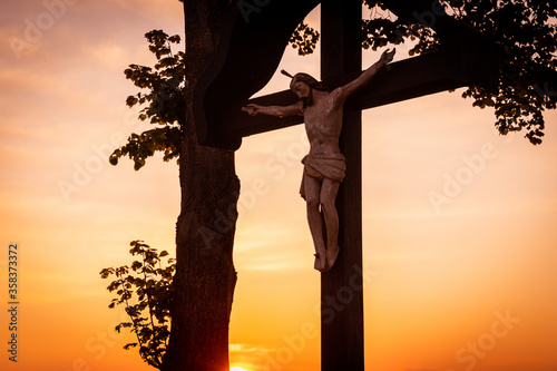 Jesusfigur am Kreuz im Abendlicht