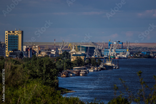 Cityscape of town Galati on Danube river from shore of Braila County, Romania at sunset