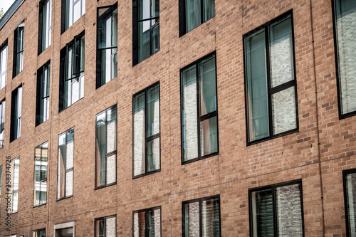 Close up of modern city building with red brick and large windows