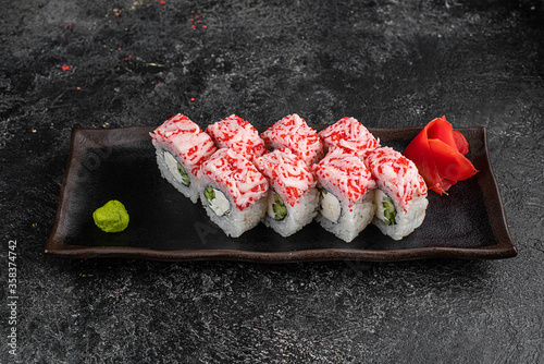 Japanese food sushi rolls California with cream cheese and masago caviar on dark background