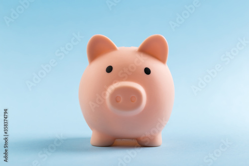 pink piggy bank on blue background. The concept of saving money or savings, investment