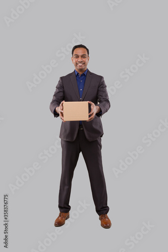 Businessman Holding Carton Box in Hands. Indian Business man with Parcel in hands.