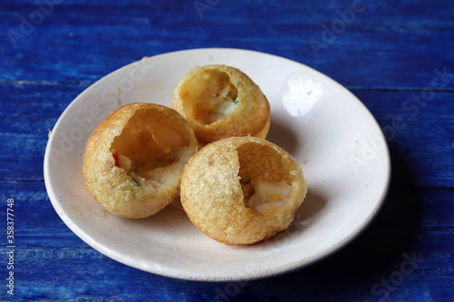 Close Up of Panipuri or Golgappa in Plate Isolated on Blue Wooden Background, Also Known as Phuchka, Paani Patashi, Gup Chup, Indian Street Food
