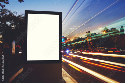 Illuminated blank billboard with copy space for your advertising text message or content, information Lightbox board outdoors with night light on background,promotional mock up banner on city roadside
