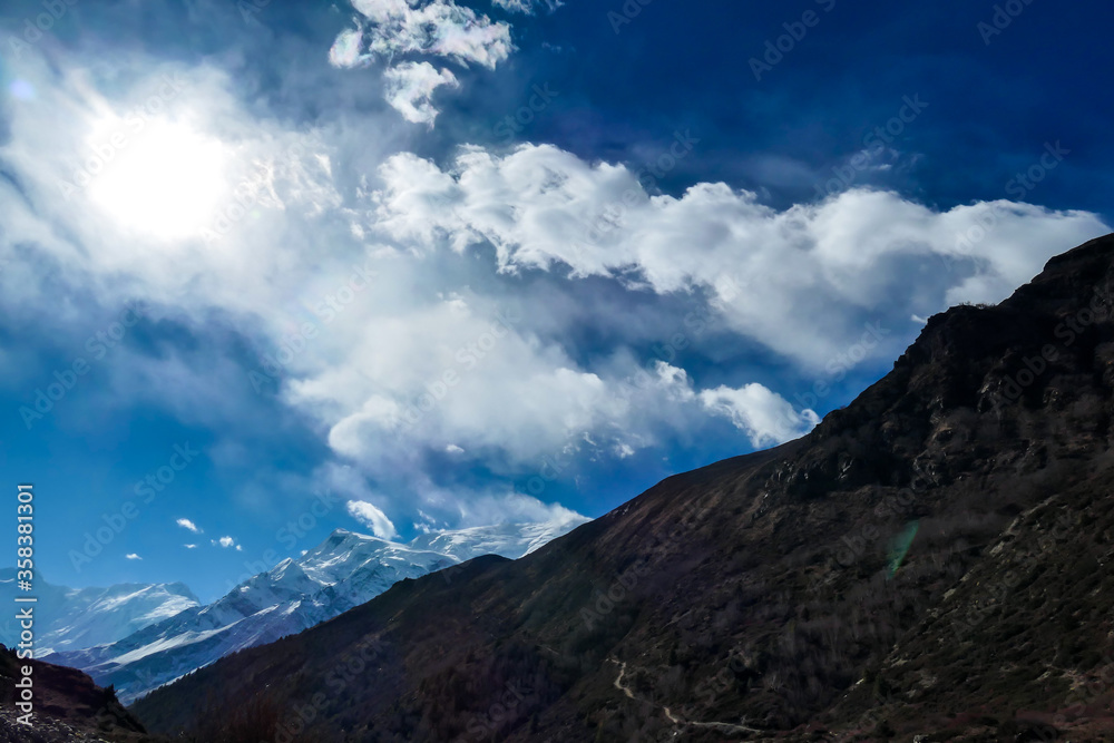 View on high Himalayas along Annapurna Circuit Trek, Nepal. Harsh and barren landscape around. Clear and blue sky. High Himalayan ranges around. Snow capped mountains. Serenity and calmness View on high Himalayas along Annapurna Circuit Trek, Nepal. Harsh and barren landscape around. Clear and blue sky. High Himalayan ranges around. Snow capped mountains. Serenity and calmness