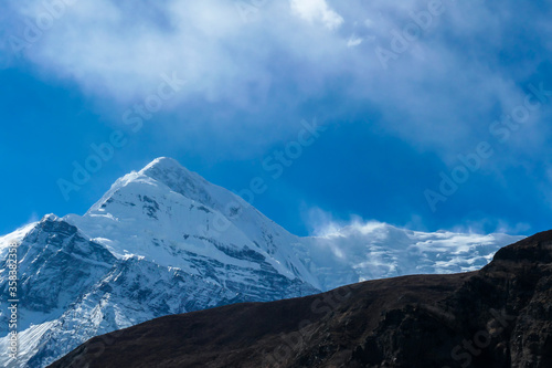 View on high Himalayas along Annapurna Circuit Trek  Nepal. Harsh and barren landscape around. Clear and blue sky. High Himalayan ranges around. Snow capped mountains. Serenity and calmness