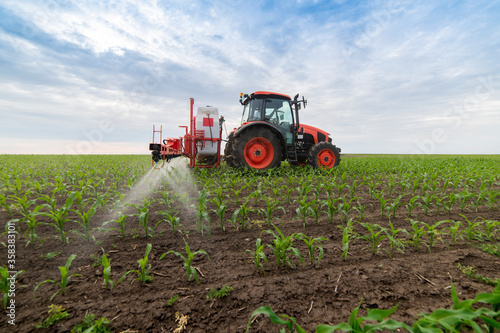 Tractor spraying pesticides at corn fields
