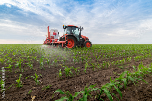 Fotobehang Tractor spraying pesticides at corn fields