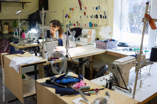 girl with a bored and dejected look at the workplace in a sewing workshop