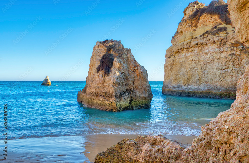 rocks rising from the calm blue ocean, Algarve, Portugal