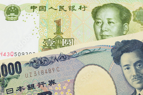 A macro image of a Japanese thousand yen note paired up with a green and white one yuan note from China. Shot close up in macro.