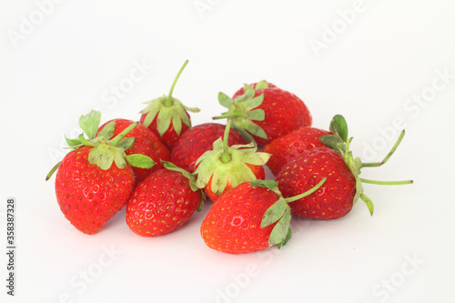 Red fresh strawberries on a white background. Green leaves of strawberries. 