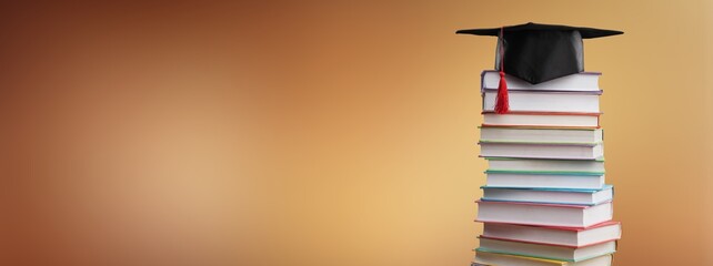 Stack school books with black graduation hat