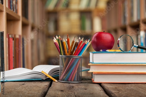 Stack of vintage books and colorful pencils on the desk