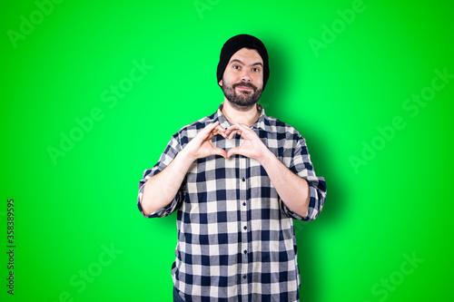 Portrait of happy handsome man making heart with fingers