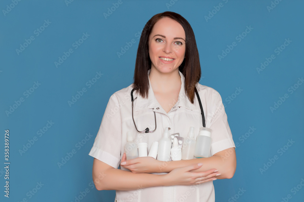 Happy doctor in white coat with a stethoscope holds medicine in his hands