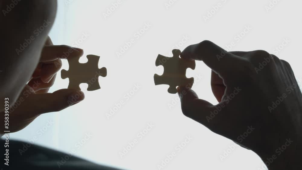 Man joins two pieces of a puzzle - concept: problem solving