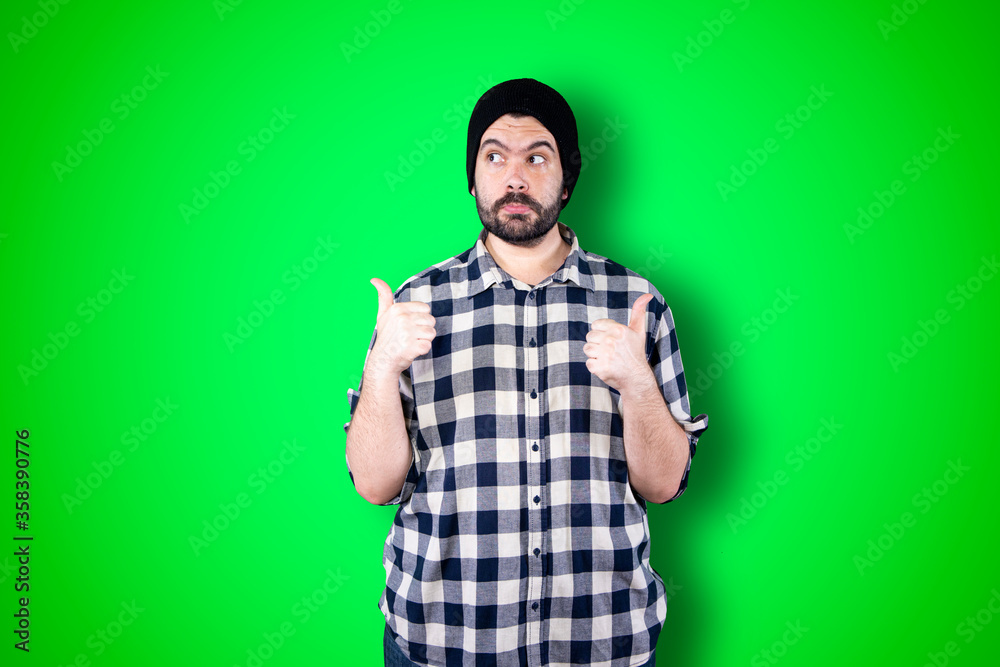 Portrait of a cheerful young man showing okay and victory gesture isolated on the chroma background Portrait of a cheerful young man showing okay and victory gesture isolated on the chroma background